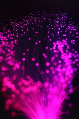 Fototapeta na wymiar Colored whims of a panicle of a lamp from a bundle of optical fiber threads. An imitation of a salute, explosion or nebula with dots of bright stars, a expanding universe.