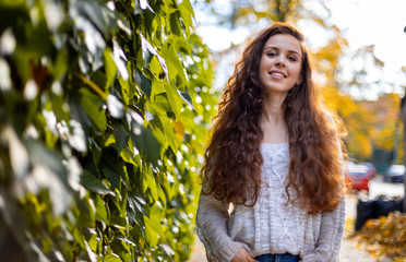 Long haired smiling woman walking on the street outdoors