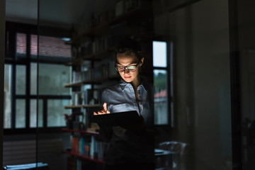 Young businesswoman using a tablet in her modern home studio office