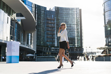 Happy businesswoman walking in the city