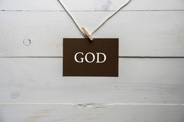Closeup shot of a sing attached to a string with god written on it