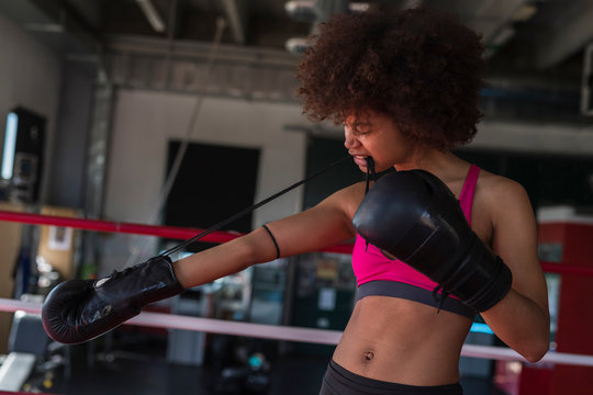 black woman boxer putting hes gloves on.