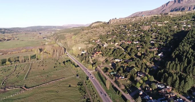 aereal drone footage of sunset in Patagonia, with vehicles arriving at the town