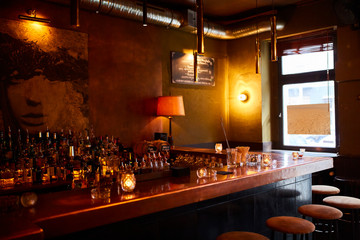 A bar tabletop with glass bottle and cups.