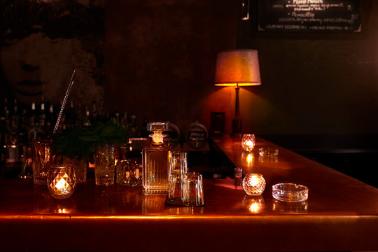 A bar tabletop with glass bottle and cups.