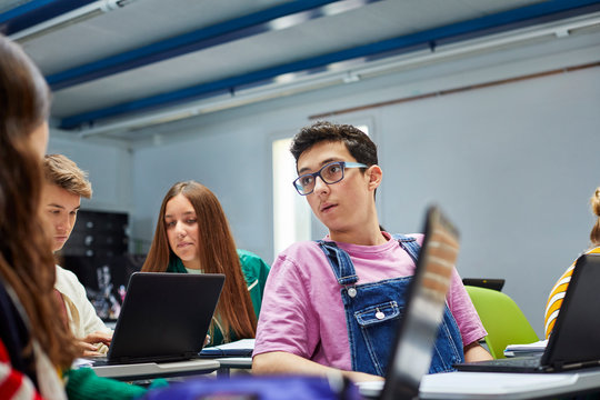 Teenage students using laptops in the classroom
