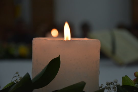 vela encendida de parafina y al fondo una mas peque&ntilde;a 