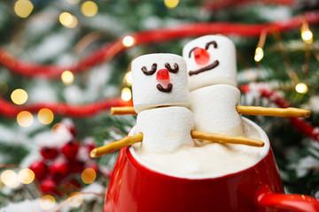Red mug with hot chocolate and two marshmallows in love. Christmas meeting a couple in love concept.