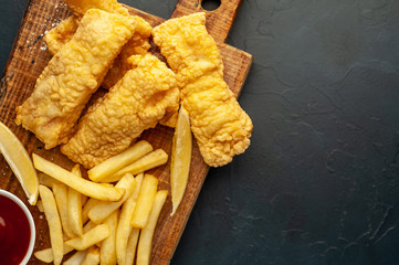 fish and chips with french fries, on a stone background  A