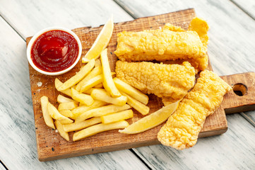 fish and chips with french fries, on wooden background
