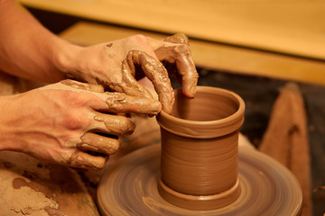 Potter makes vase on a potter's wheel. hands of a potter.