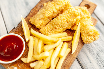 fish and chips with french fries, on wooden background