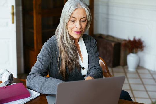 Senior woman working at home office.