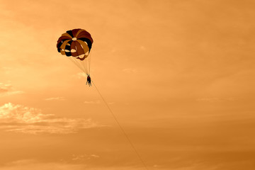 Parasailing in the evening sky near the coast of Vietnam. Orange color toned