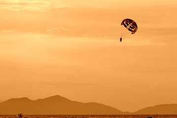Parasailing in the evening sky near the coast of Vietnam. Orange color toned