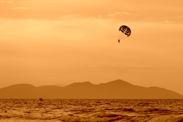 Parasailing in the evening sky near the coast of Vietnam. Orange color toned