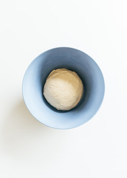 Premade bear bread dough resting and rising in blue container
