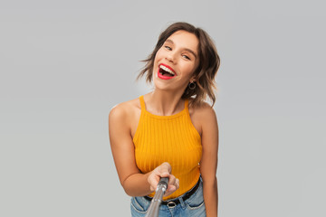 winning gesture, emotions and people concept - happy smiling young woman in mustard yellow top...