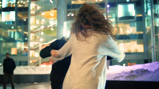 Happy young couple dancing latin dance together in night winter city street.  Slow motion, 4K UHD	