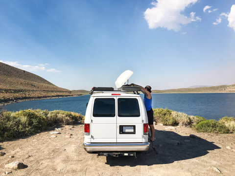 Man Loading Van Roof Rack at Mountain Lake