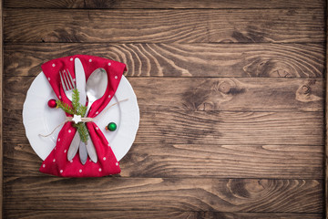 Christmas table place setting with red and white polka dot napkin on the wooden background