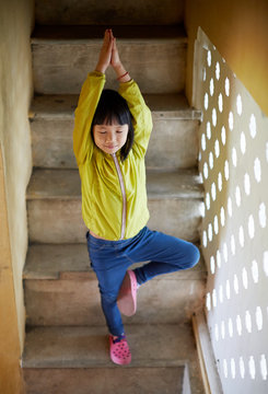 Cute Asian little girl on the quaint stone steps. Travel in Hanoi