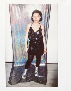 Bougie Woman In Partywear Standing On Holographic Fabric