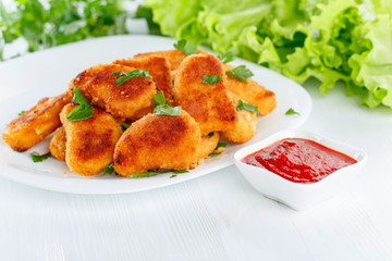 Fried chicken nuggets with ketchup sprinkled with chopped parsley.