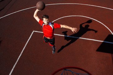 A jumping basketball player throws a ball into a basketball hoop. Slam dunk in the opponent's...