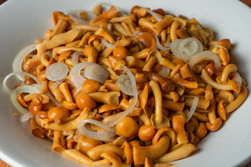 Pickled mushrooms with onions in a plate. A tasty snack for any dish.