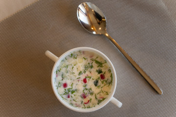 Summer yoghurt cold soup with radish, cucumber, and dill on the table, Flat lay. Okroshka.
