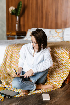 Casual girl with notepad in bedroom