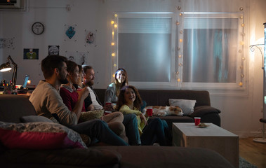 Movies night - group of friends watching a movie together at home