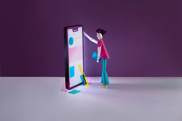 Paper girl wireframing an app on paper phone