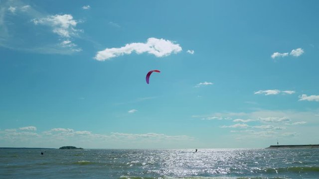 Panoramic views of young people kitesurfing in the tropical blue ocean. Kitesurfers enjoying wind power. Kitesurfing on a tropical island. 4k footage.