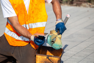 Worker cleaning a dirty trowel with sponge