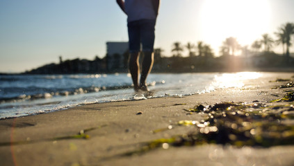 Blurred silhouette of a man on the beach during sunset.