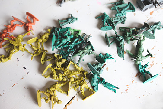 Collection of plastic army soldier figurines on white table top - Powered by Adobe