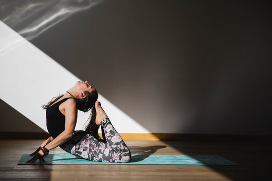 Woman doing back arching exercise during yoga practice
