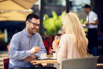 Cheerful man enjoying in conversation with his girlfriend while being in a cafe.