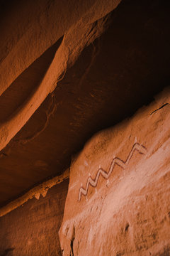 Petroglyph on orange rock wall