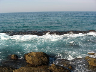 A gentle swell washes over a partly submerged reef.