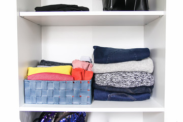 Different clothes in home wardrobe. Small space organization. Vertical storage.