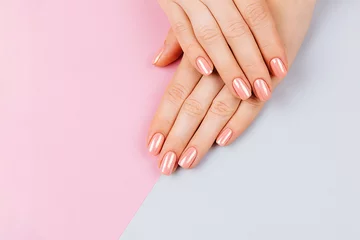 Foto op Aluminium Mooie vrouw handen. Spa en manicure concept. Vrouwelijke handen met roze manicure. Zachte huid, huidverzorgingsconcept. Schoonheid nagels. over beige achtergrond. © Vera