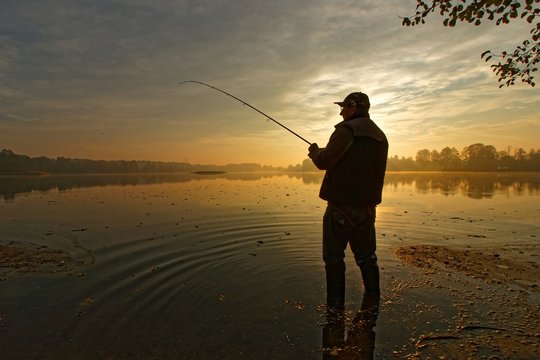 fisherman silhouette during autumnal dawn