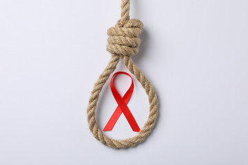 Awareness red ribbon and suicide rope on white background, copy space