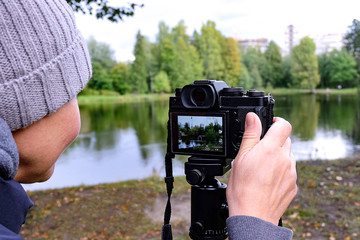 Girl photographer. The tripod with the camera.