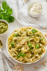 Large portion of noodles with fresh basil pesto and pine nuts