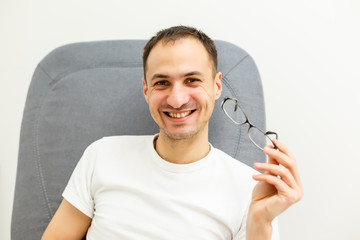 Young man puts his glasses on