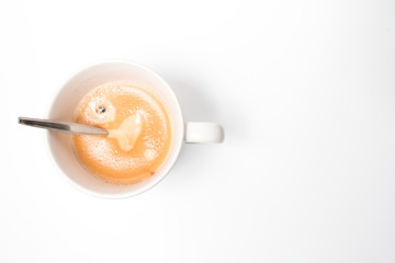 A hot fresh cup of coffee with a nice layer of coffee cream with a white background, top view.